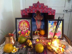 typical puja setup. the framed posters are widely available and inexpensive, to promote religion among the people whether they have money or not. 